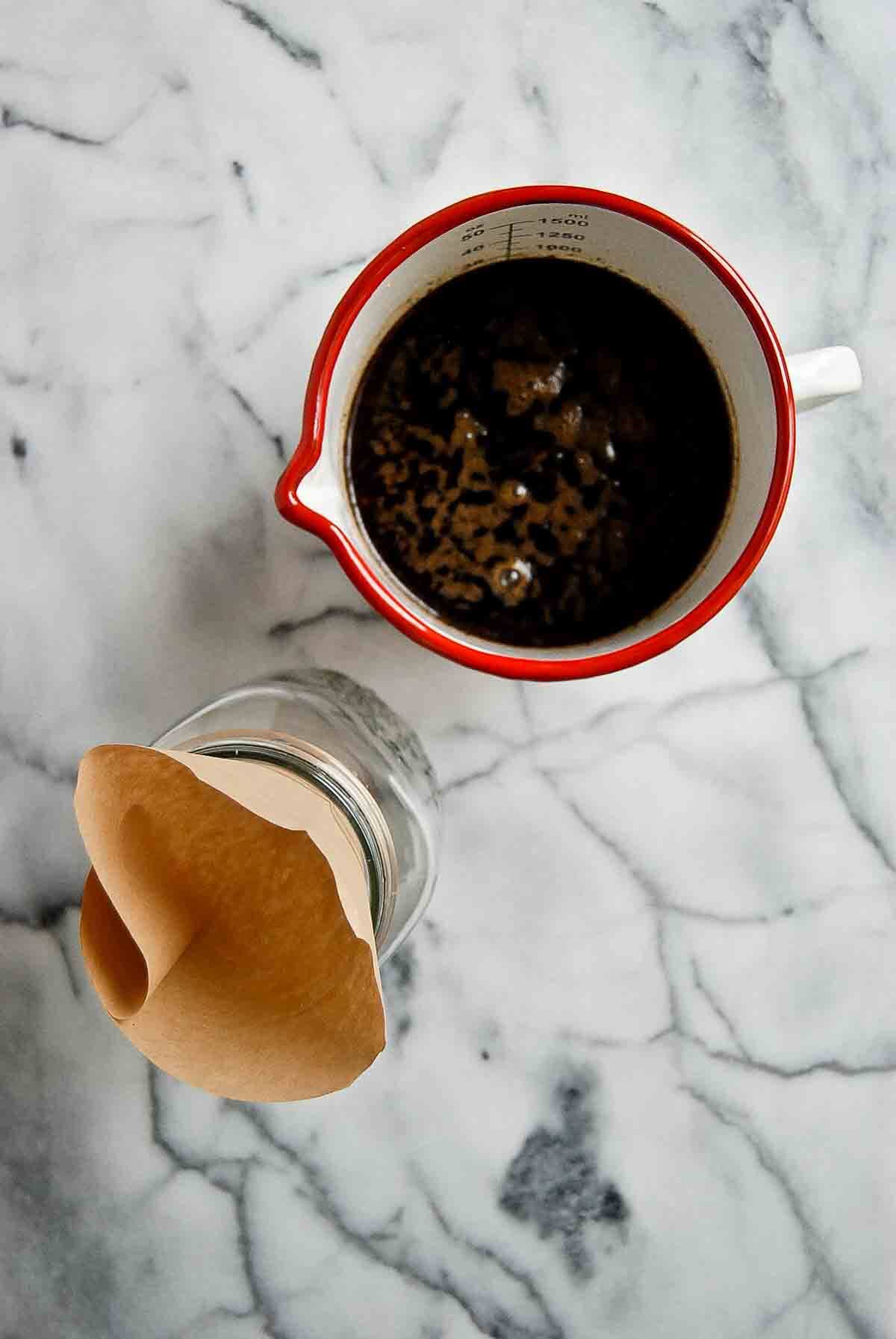 coffee in pitcher with strainer next to it.