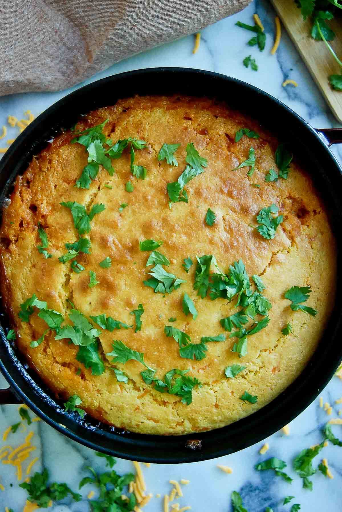 closeup of cornbread cowboy casserole in dutch oven on countertop.