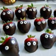halloween chocolate covered strawberries on serving tray.