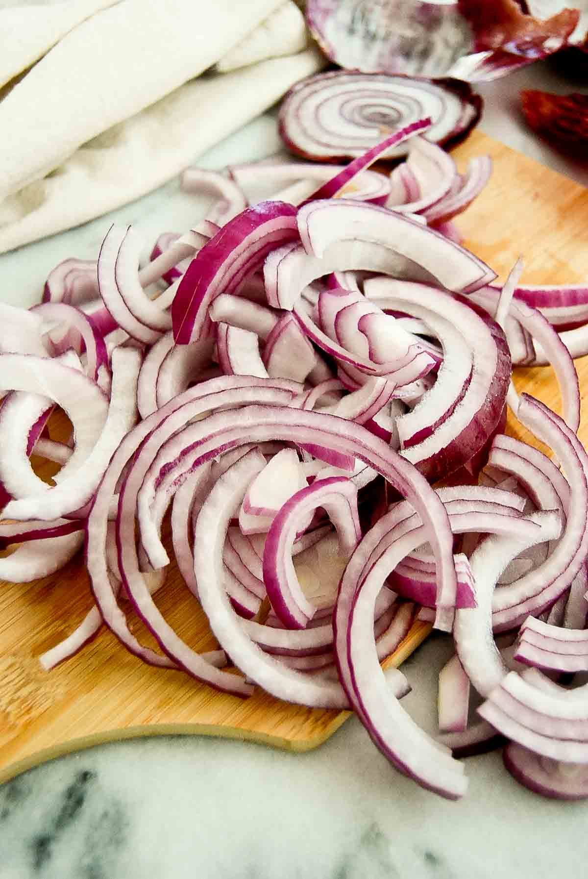 sliced onions for fajitas on cutting board.