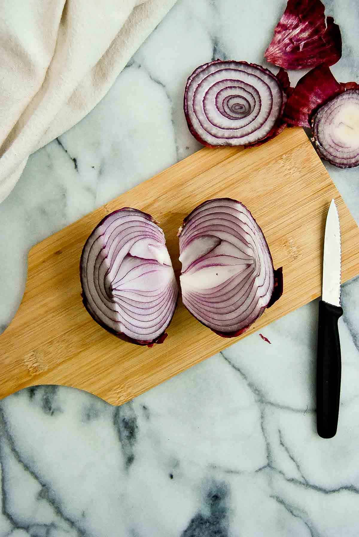 1 onion cut in half on cutting board.