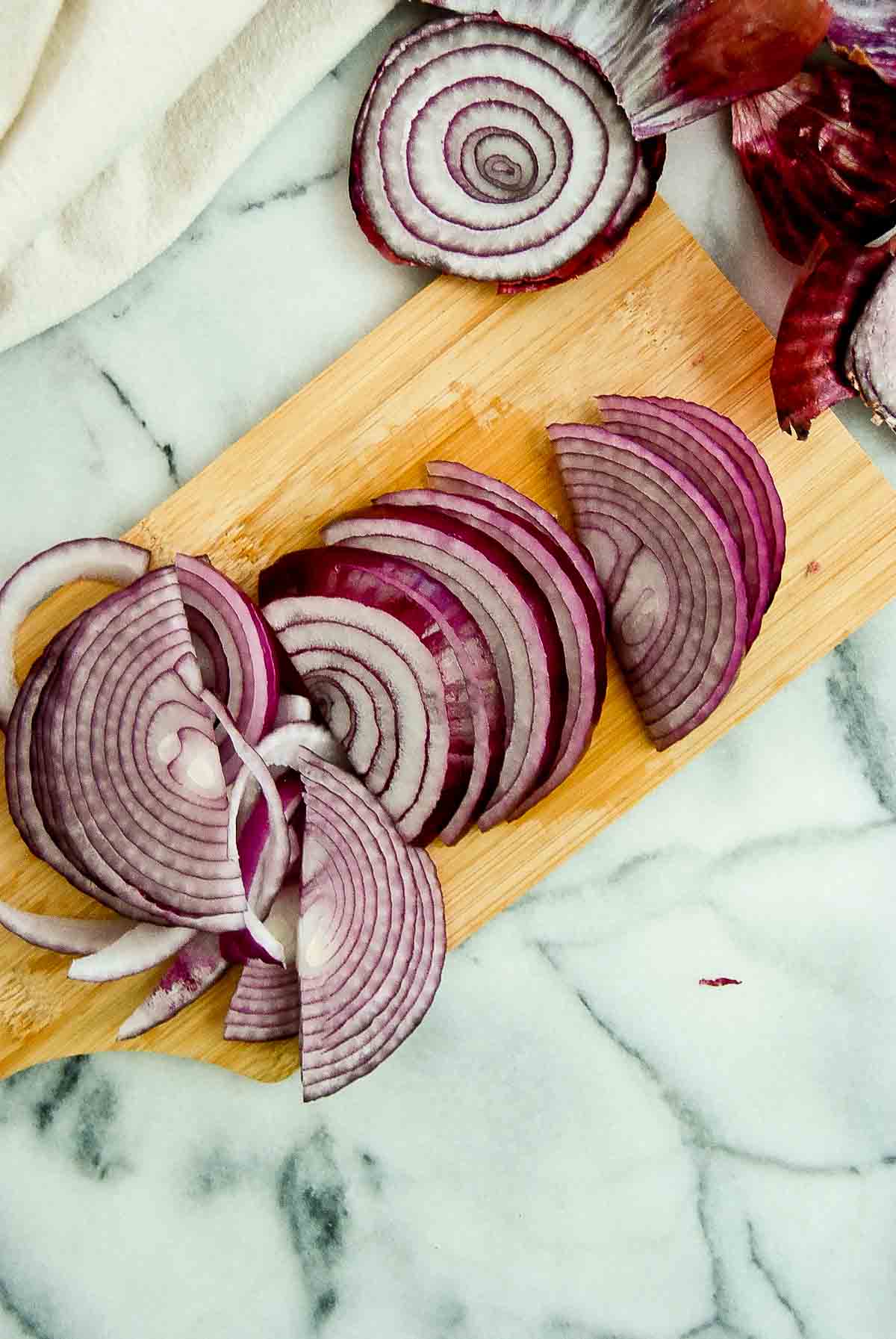 half onion sliced on cutting board.