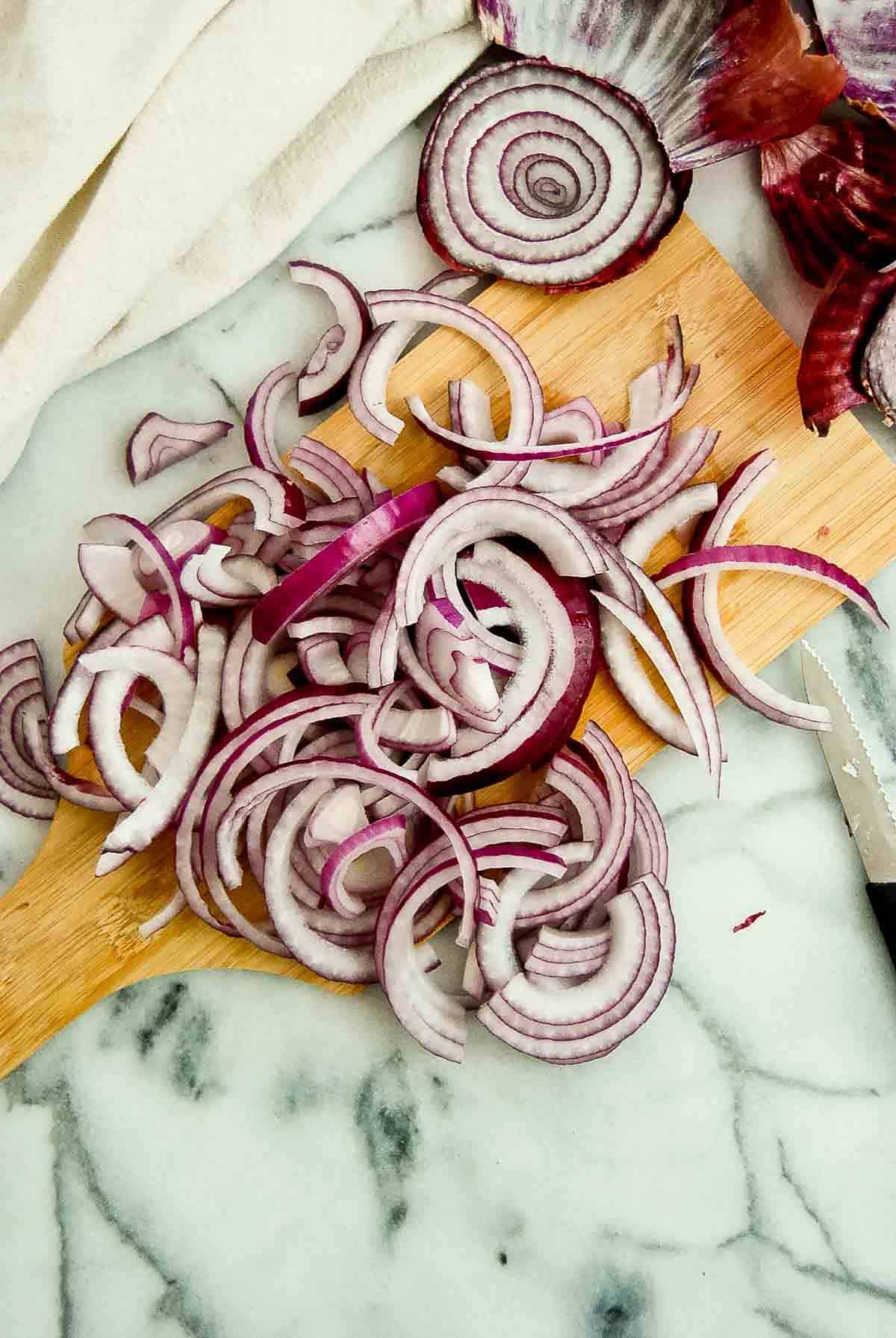 sliced onions for fajitas on cutting board.