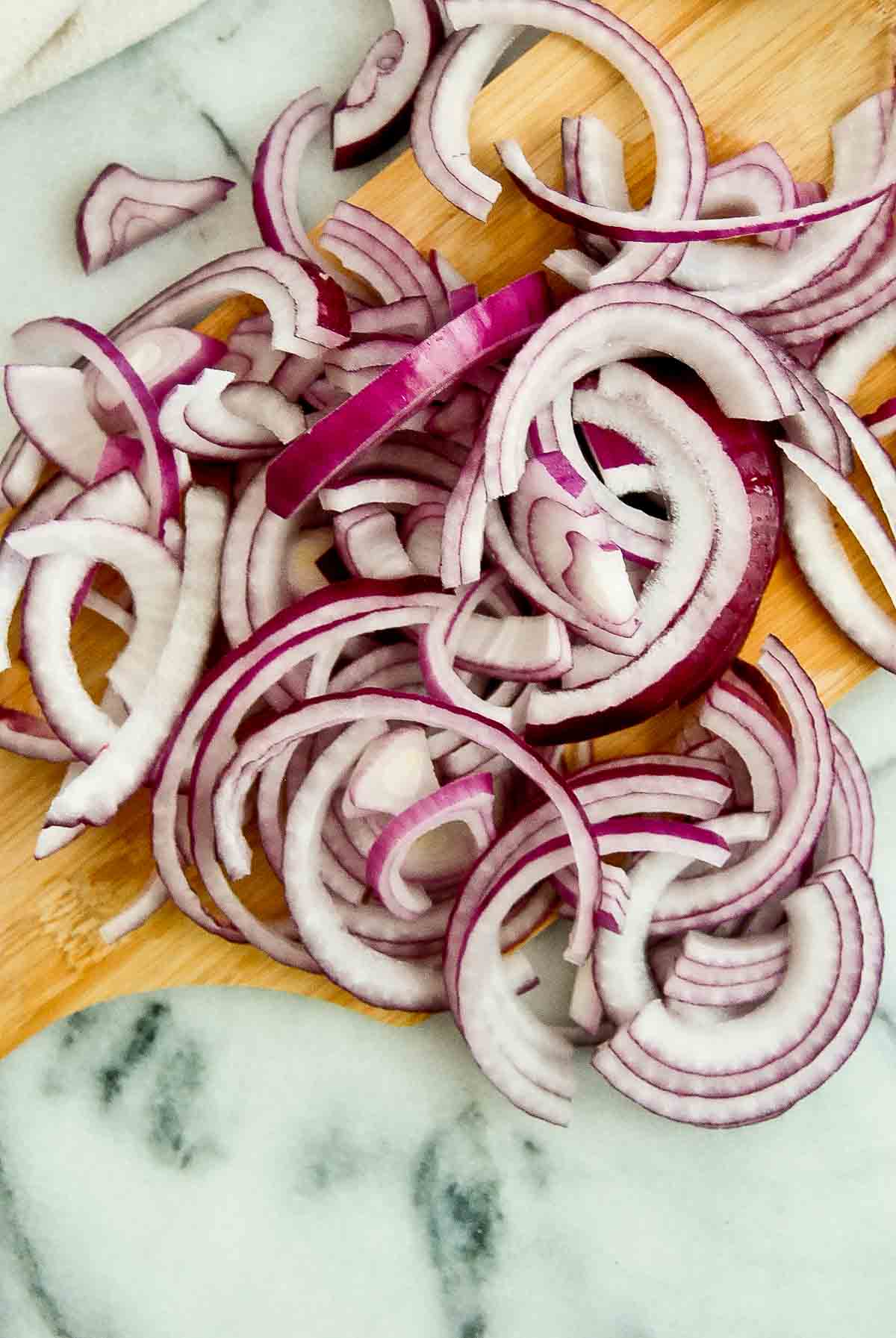 sliced onions for fajitas on cutting board.