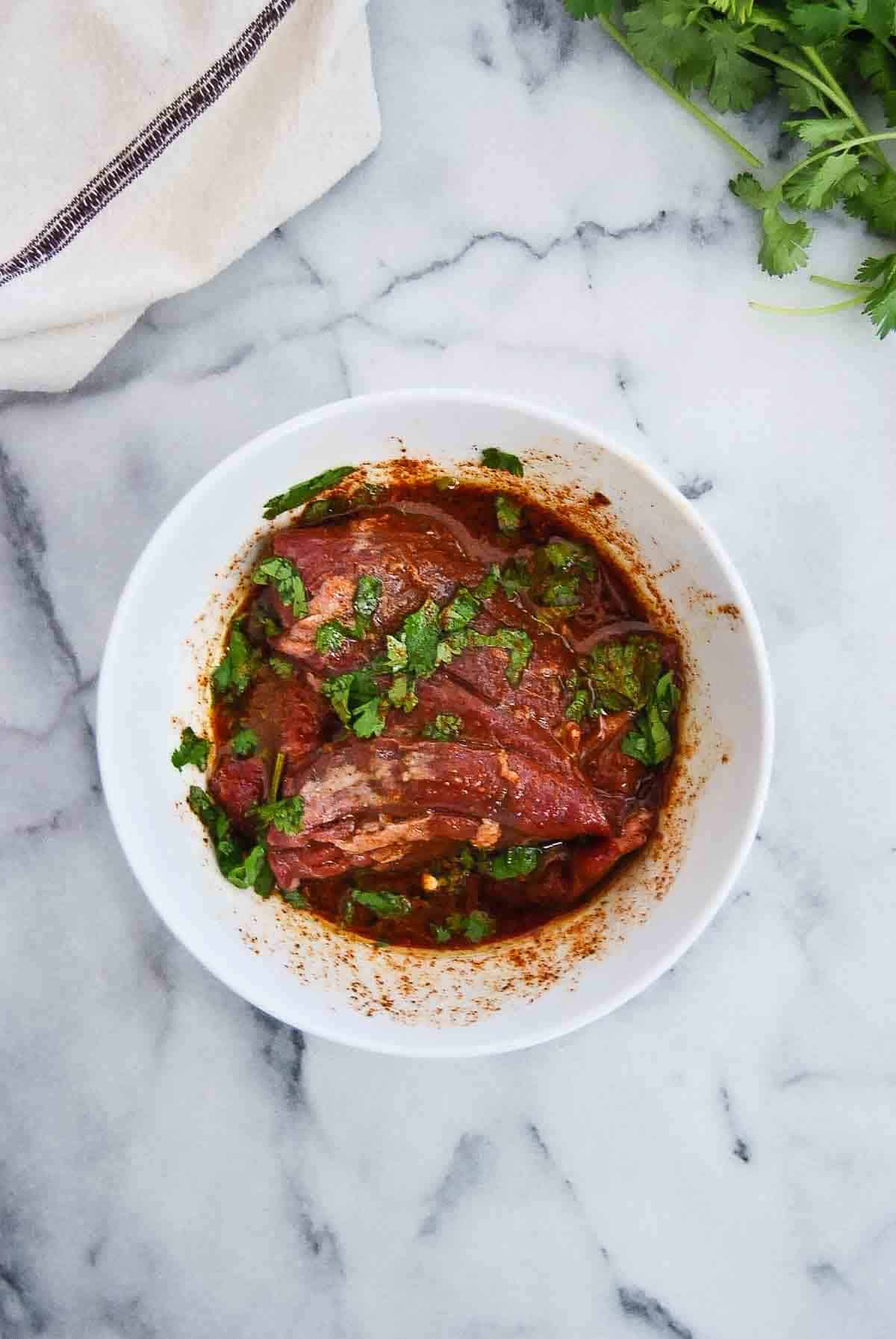 skirt steak marinating in bowl.