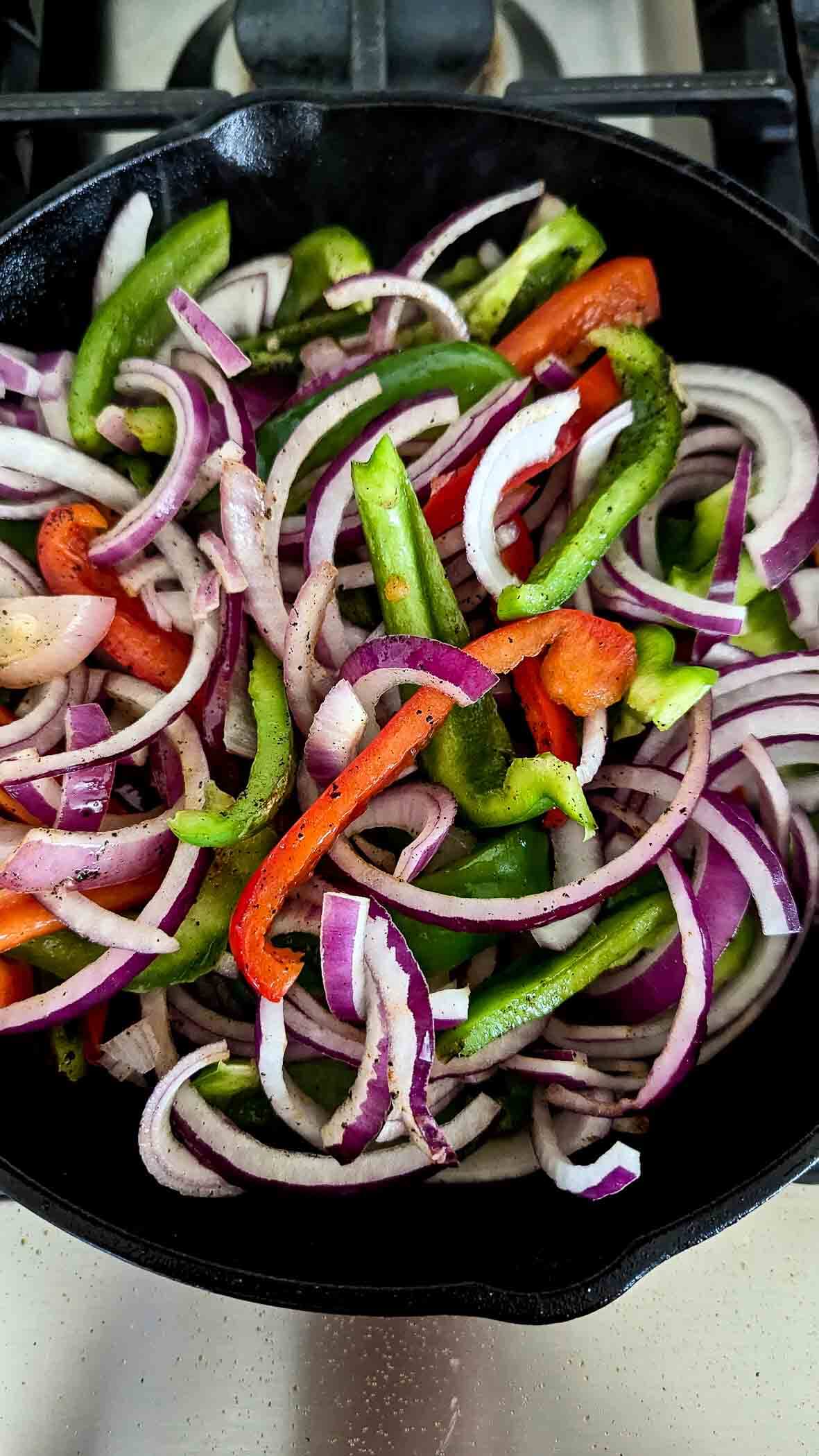 onions and red and green bell peppers, sliced, in cast iron skillet.