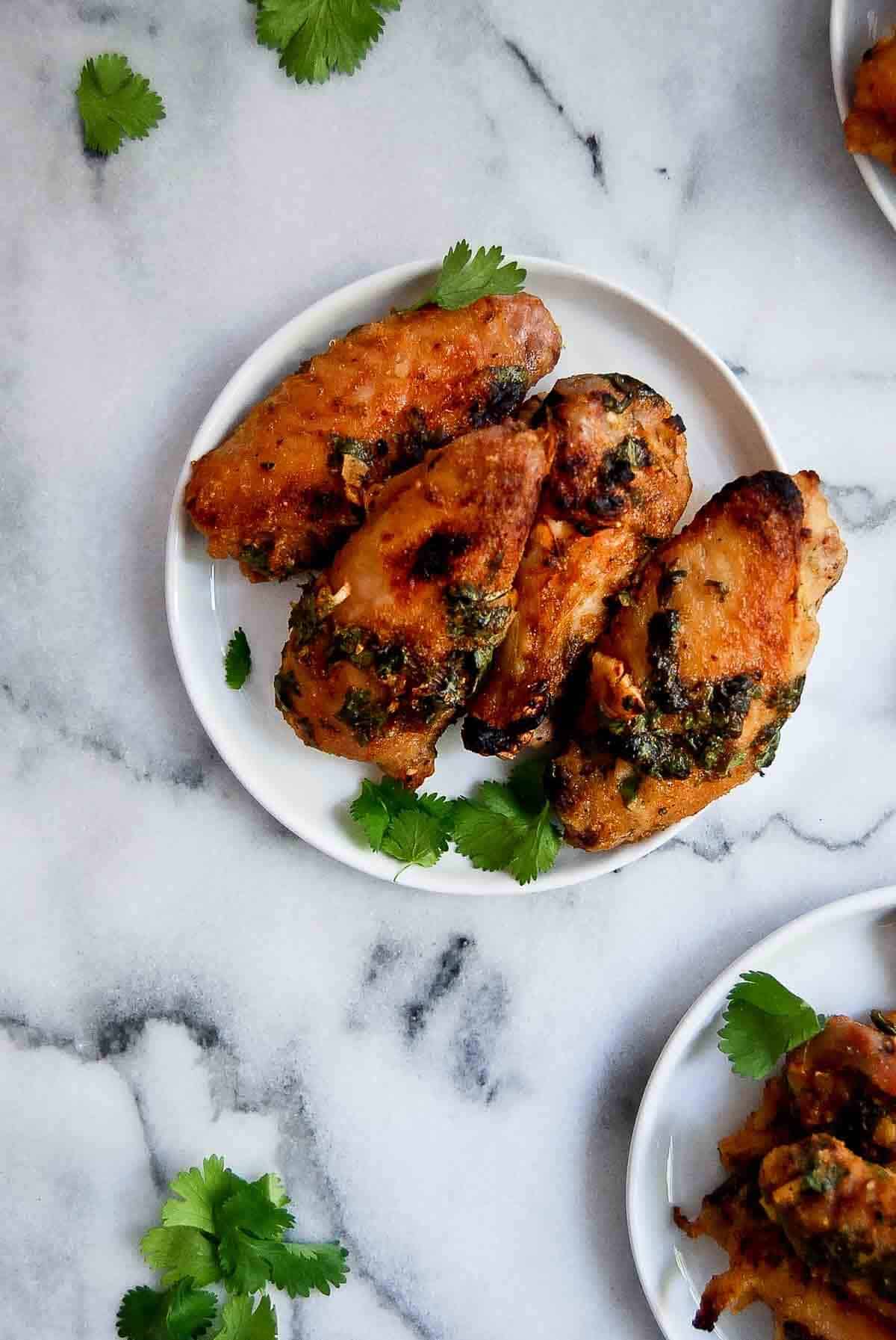 tequila lime chicken wings on plate with cilantro on top.