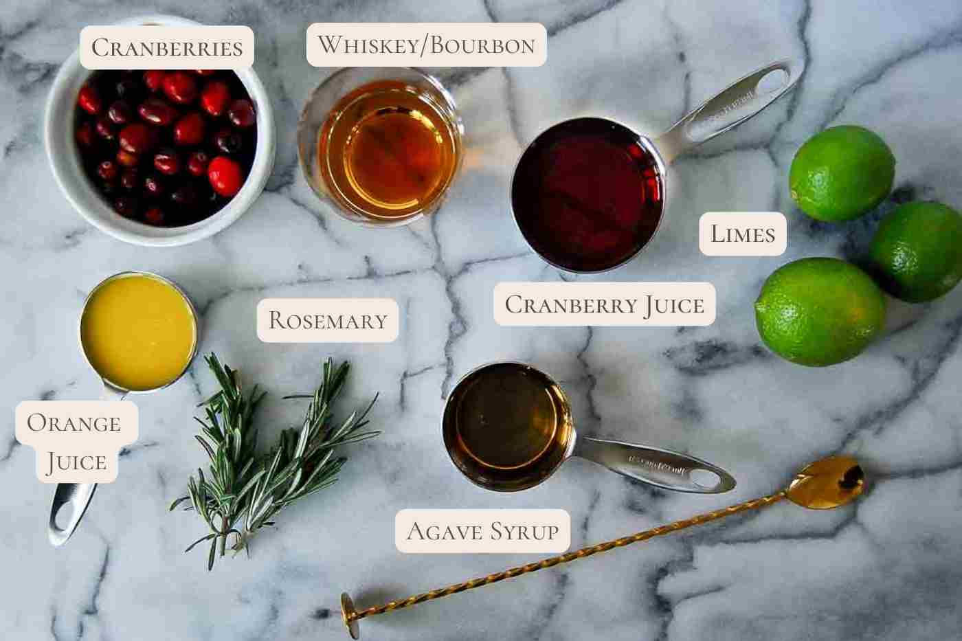 ingredients for cranberry orange whiskey sour cocktail on countertop, labeled.