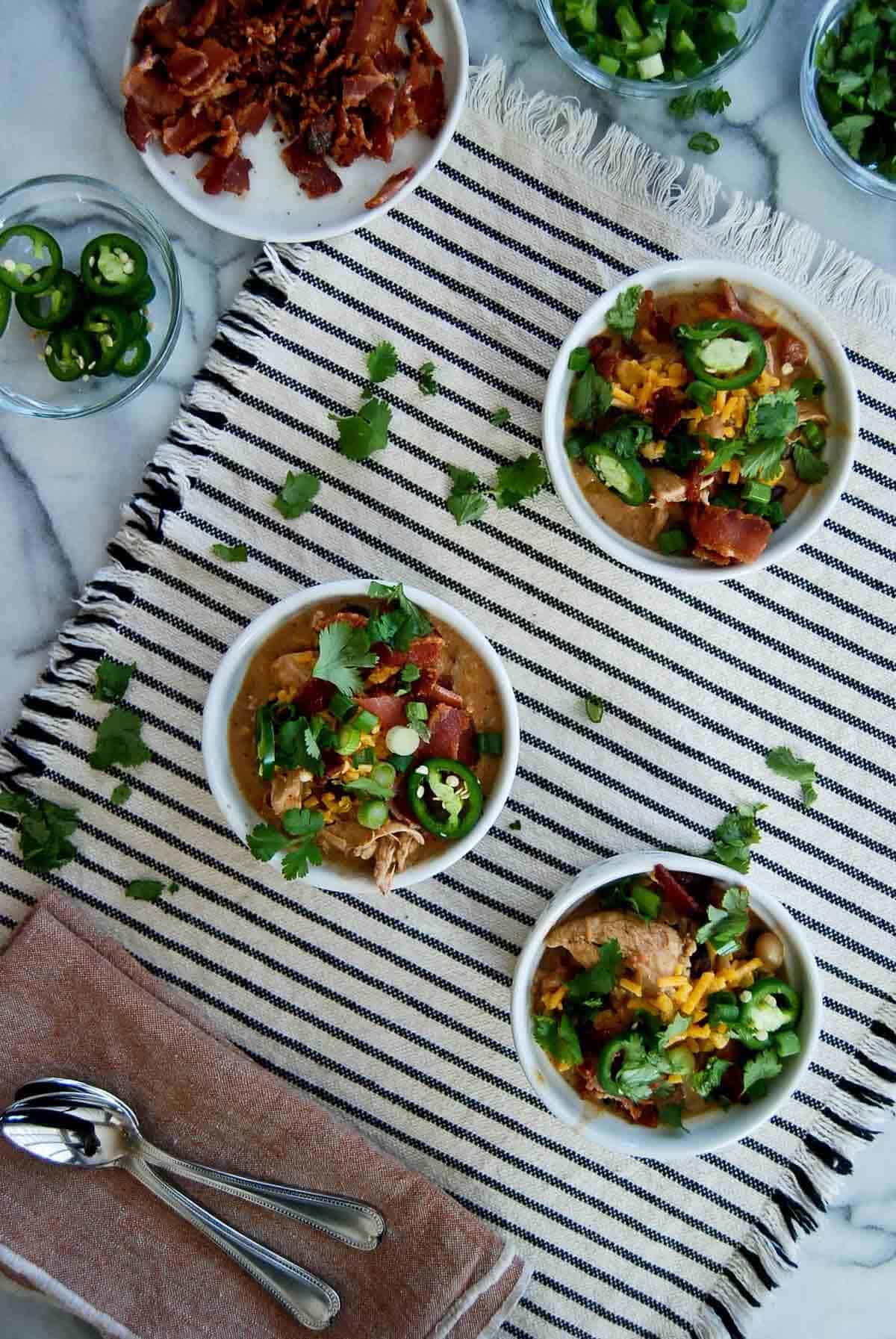 three bowls of crack chicken chili on countertop.