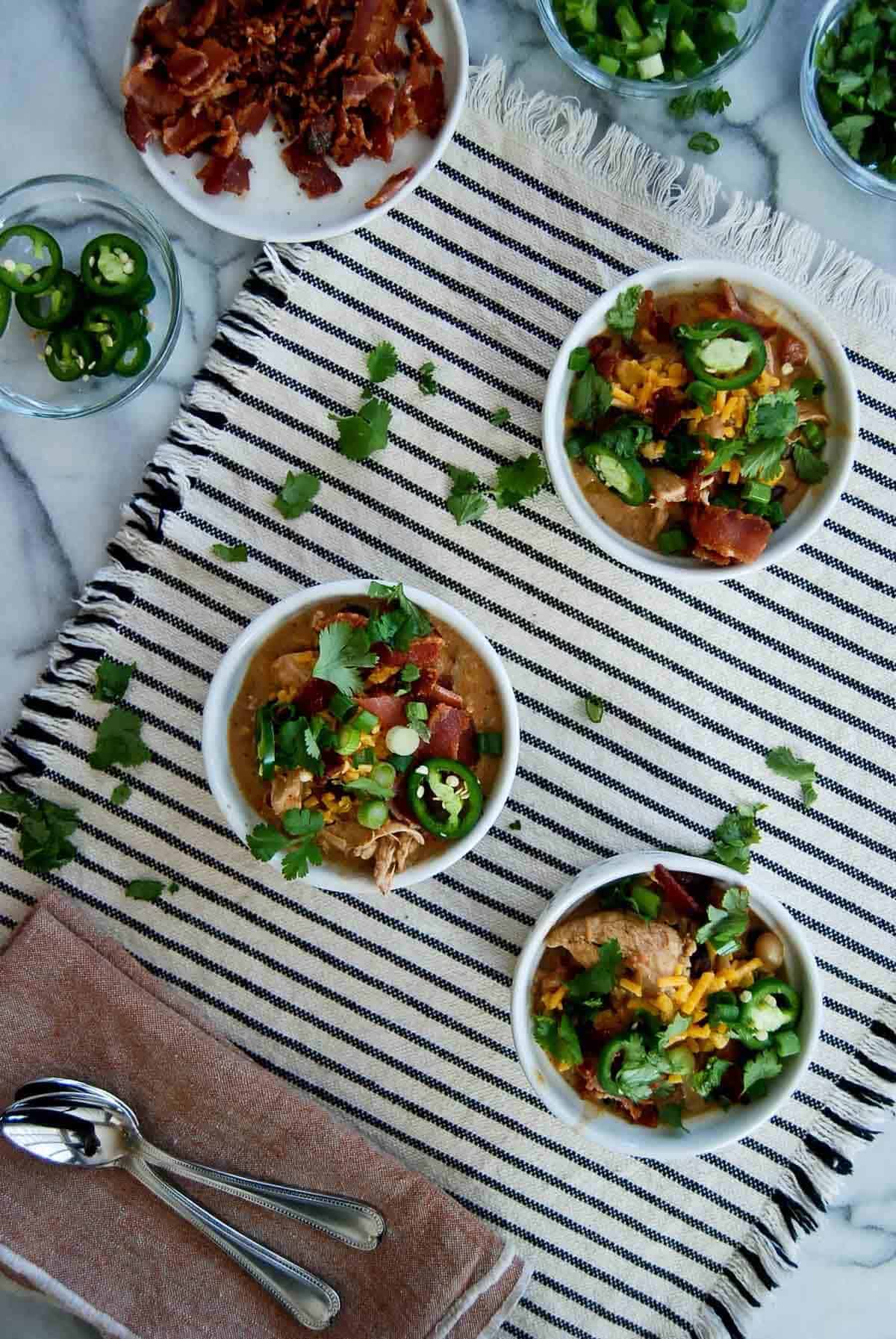 three bowls of crack chicken chili on countertop.