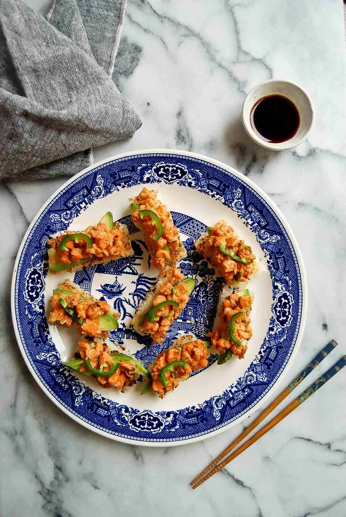 crispy rice with spicy shrimp salad with chopsticks and soy sauce on the side.