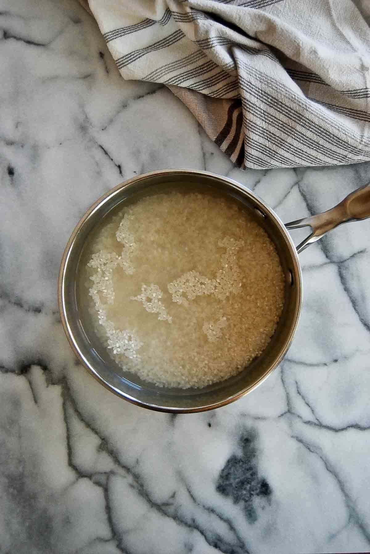 sushi rice soaking and rinsing in cold water.