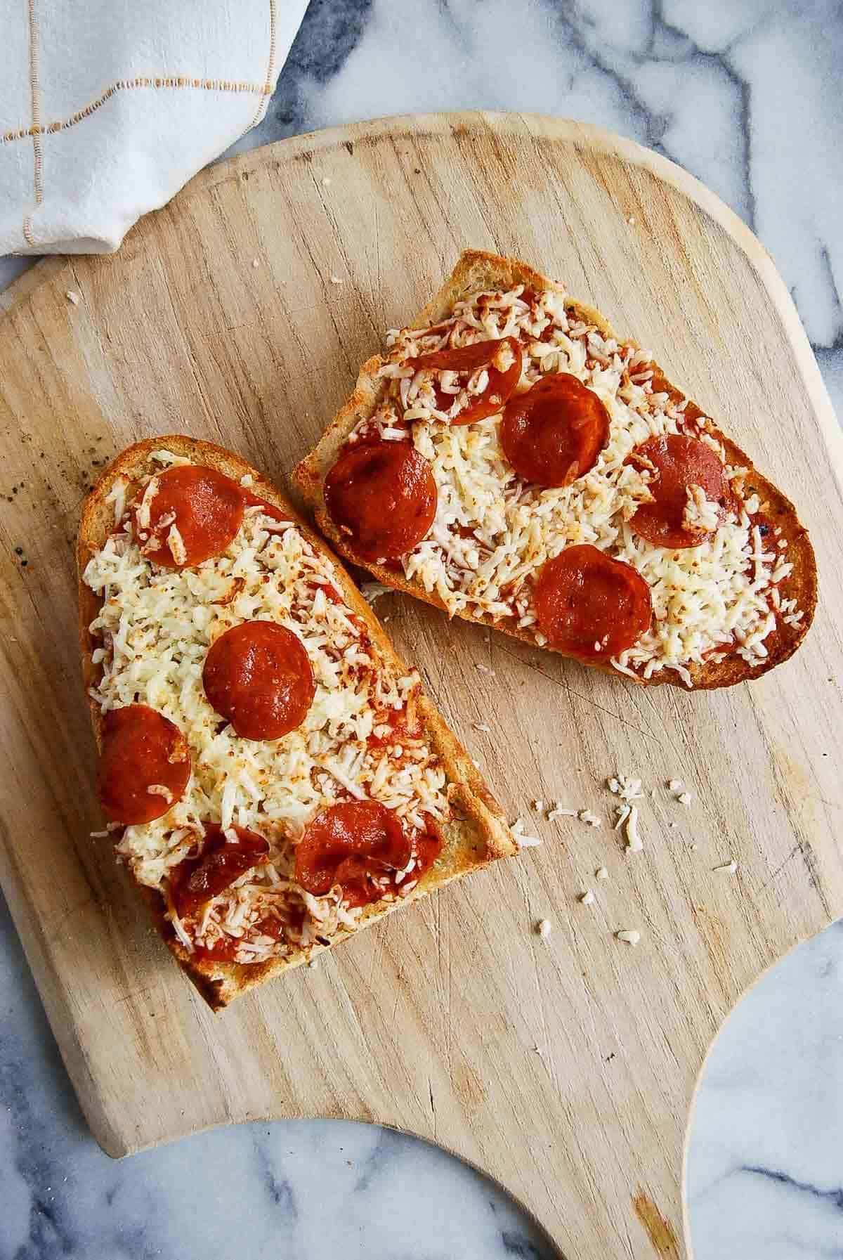 french bread pizza made in the air fryer, on a cutting board.