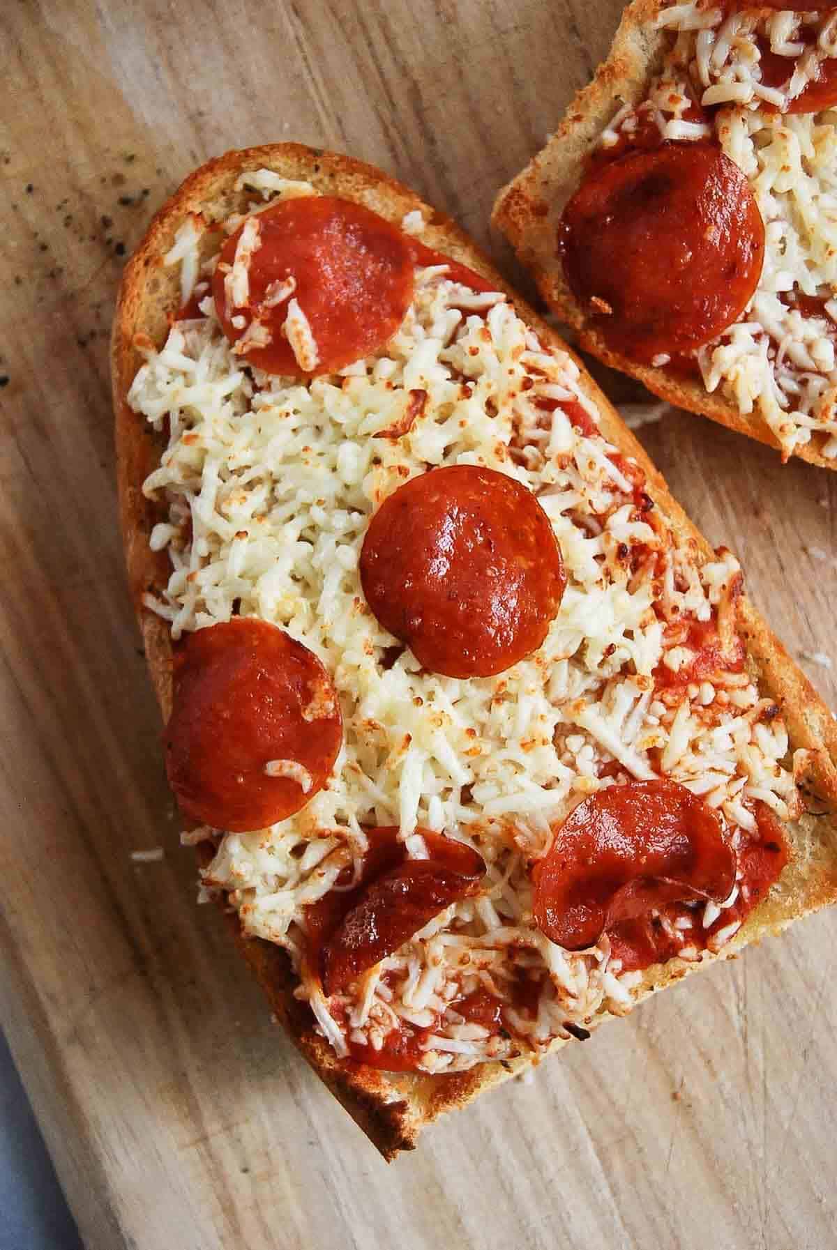 french bread pizza made in the air fryer, on a cutting board.