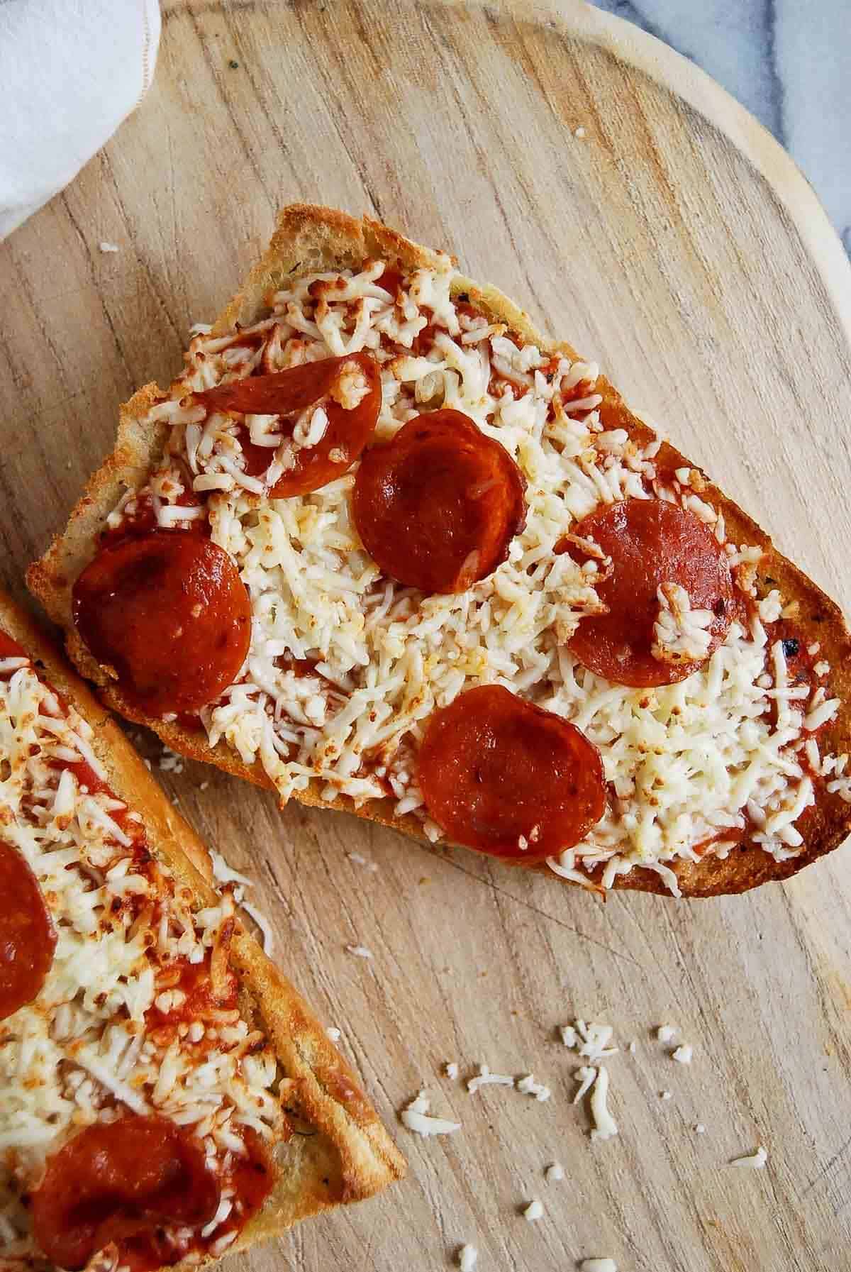 air fryer french bread pizza on cutting board.
