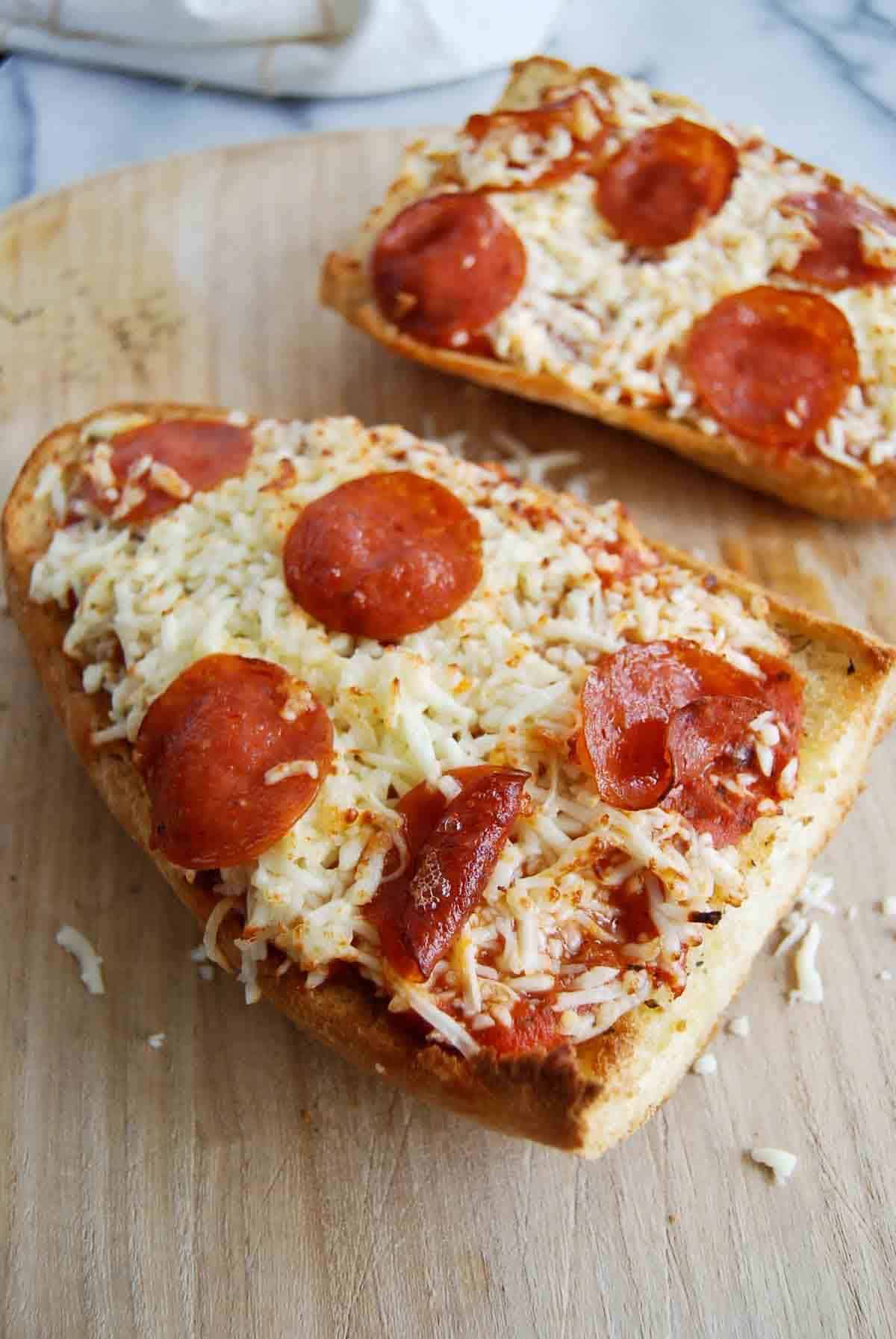 french bread pizza made in the air fryer, on a cutting board.