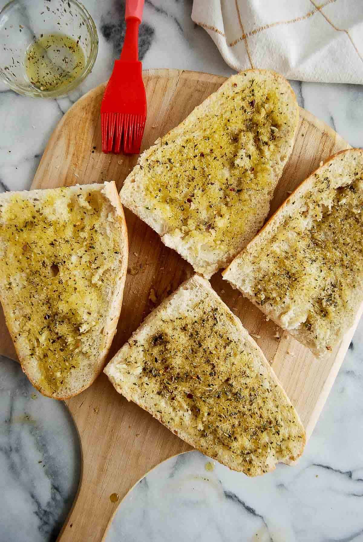 french loaf halves brushed with olive oil and italian seasoning.