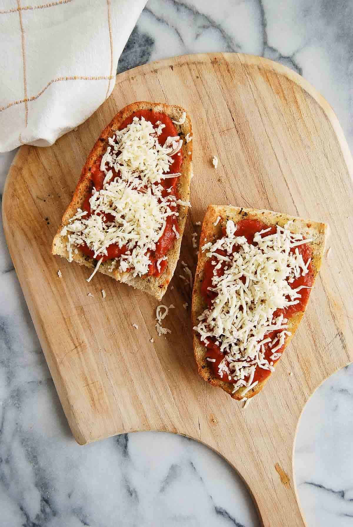 Toasted french bread pieces with pizza sauce and mozzarella cheese on the top.
