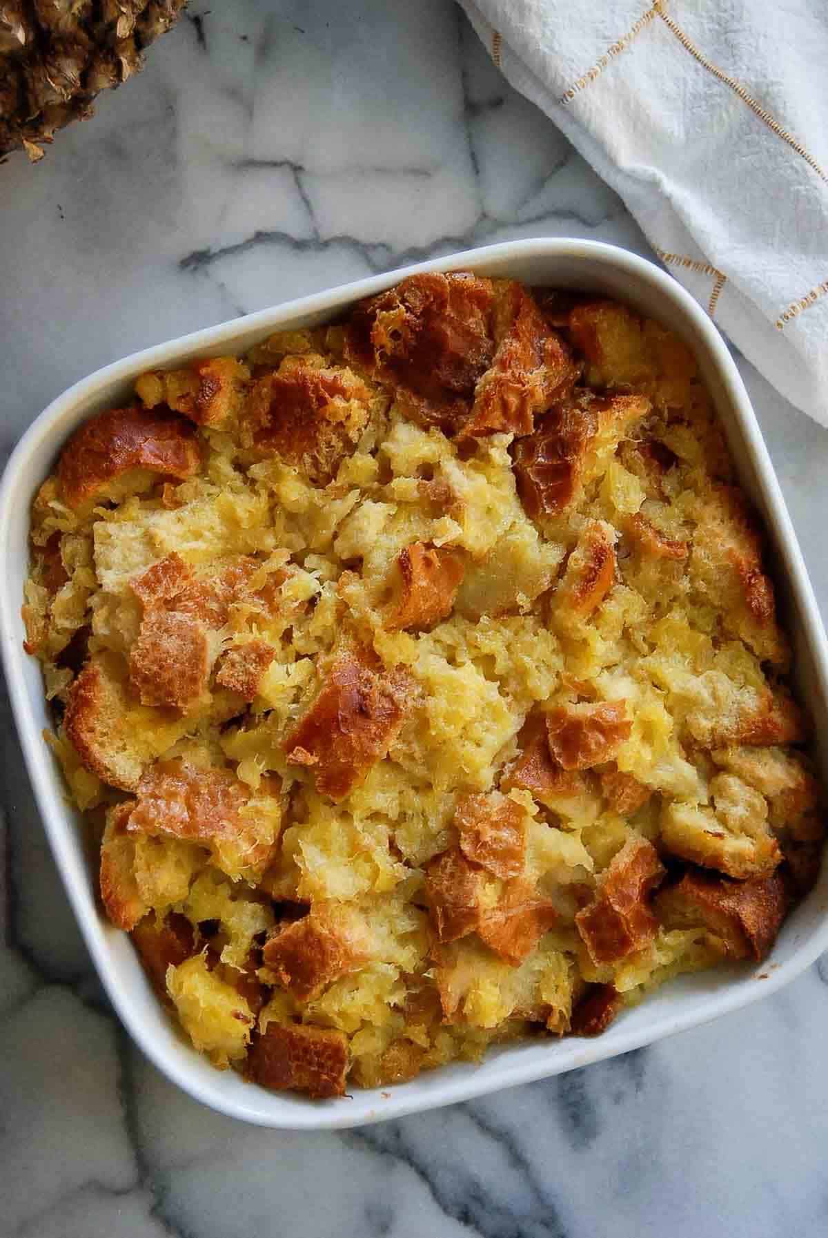 baked scalloped pineapple in baking dish.