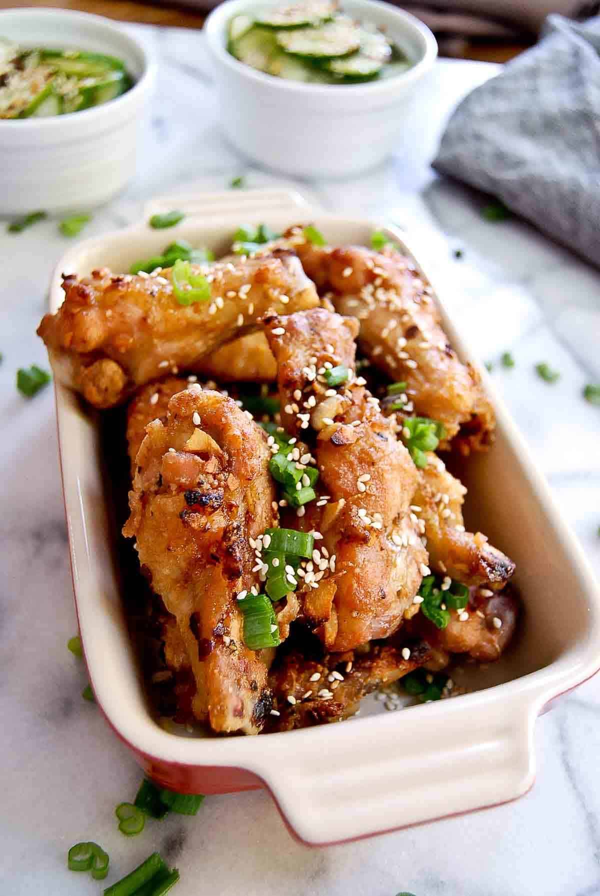 side view of soy garlic chicken wings in serving bowl.