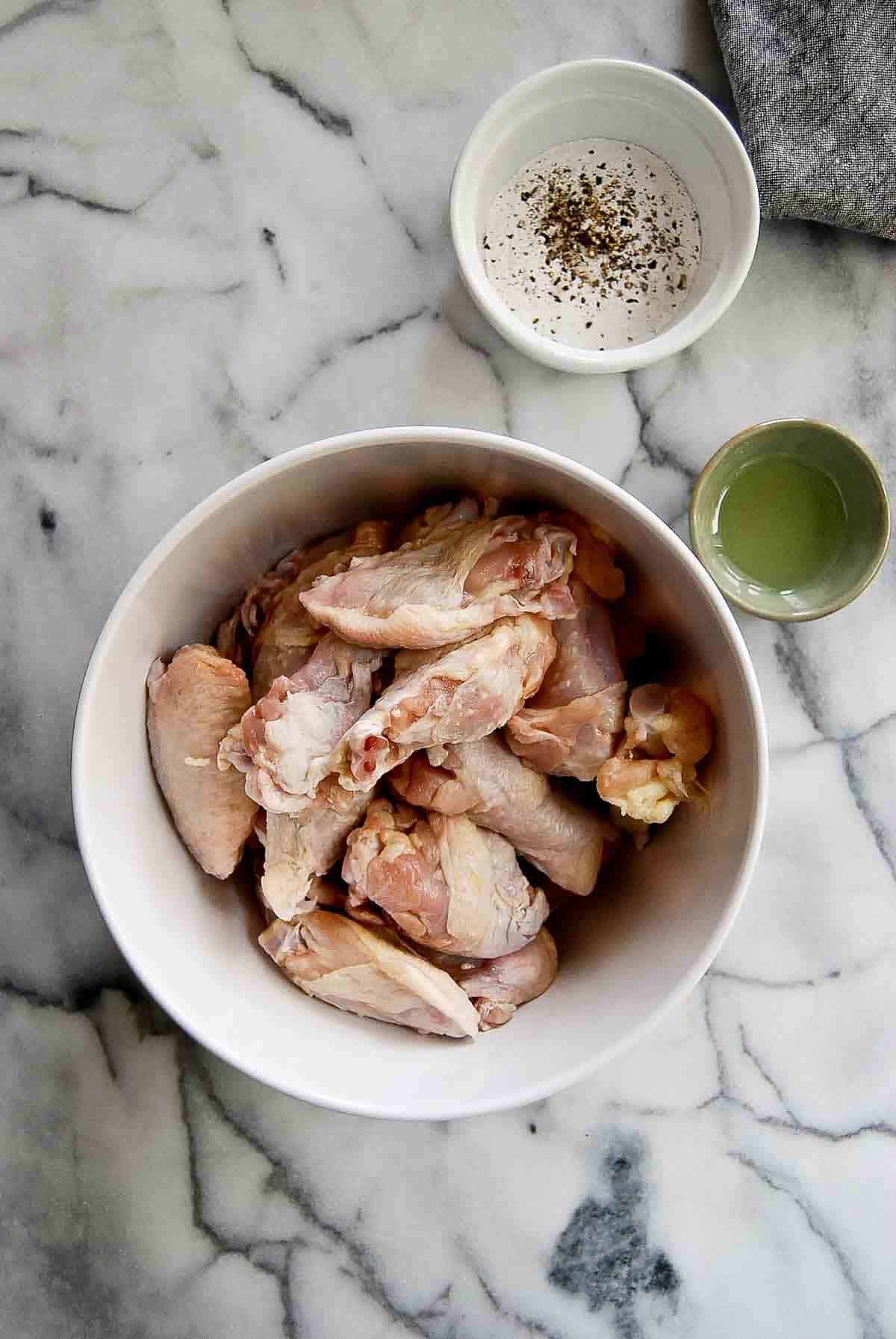 chicken wings with baking powder mixture on countertop.