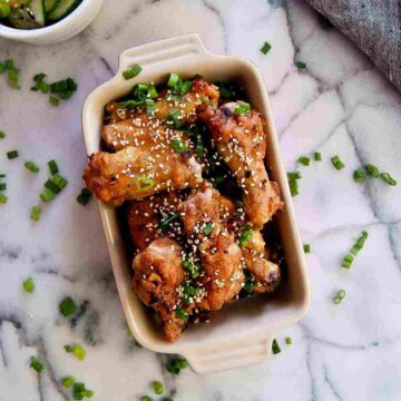 soy garlic chicken wings in serving bowl on countertop.