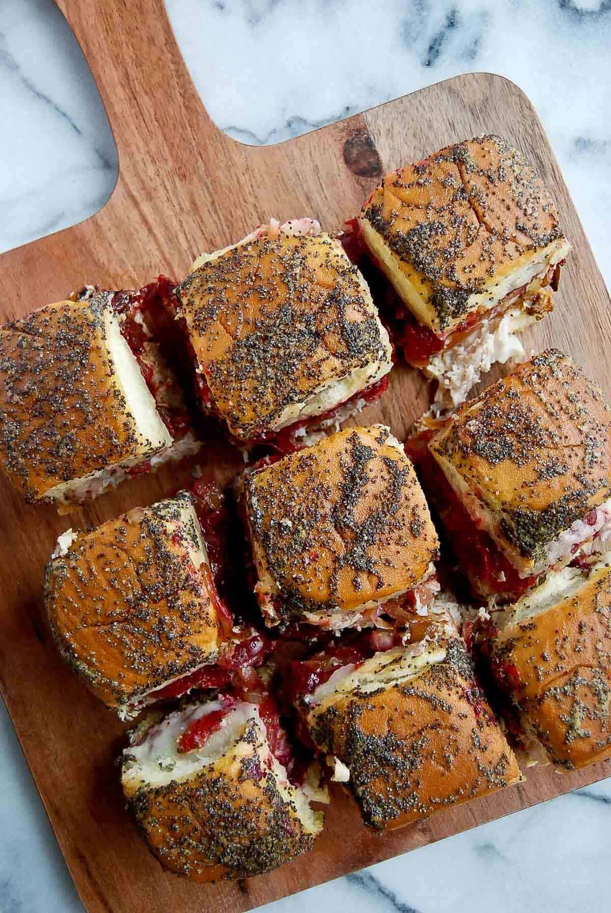 closeup of turkey cranberry sliders on cutting board.