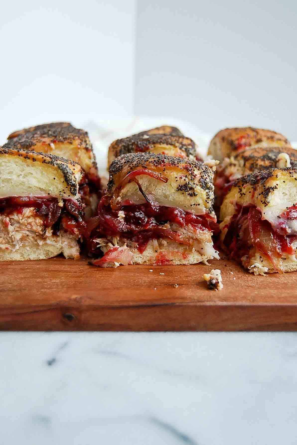 turkey cranberry sliders on cutting board.