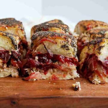 closeup of turkey cranberry sliders on cutting board.