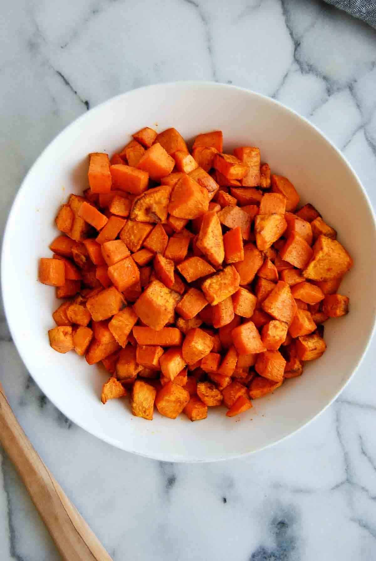 air fryer roasted sweet potato cubes in bowl on countertop.