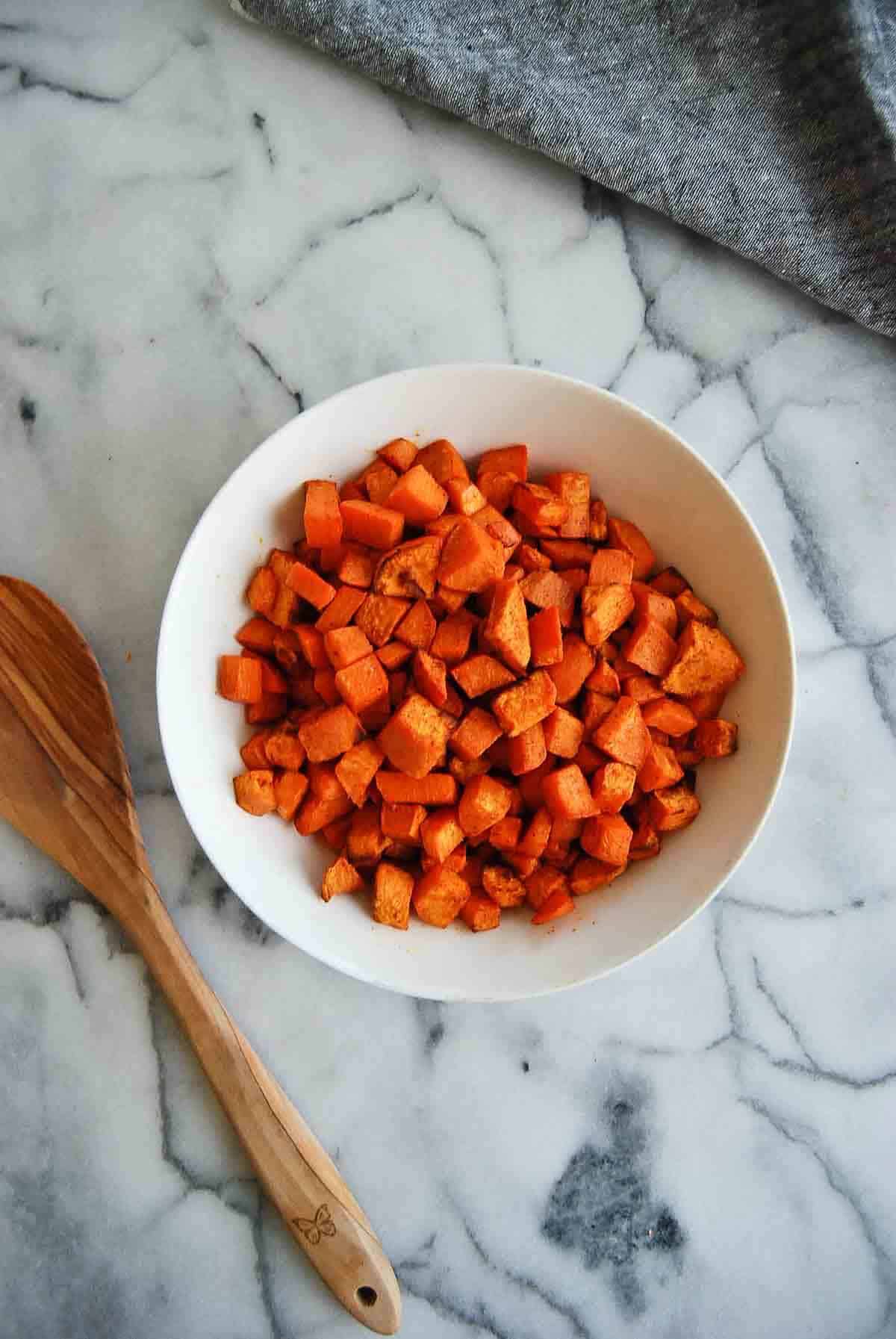 air fired sweet potato cubes in bowl on countertop.