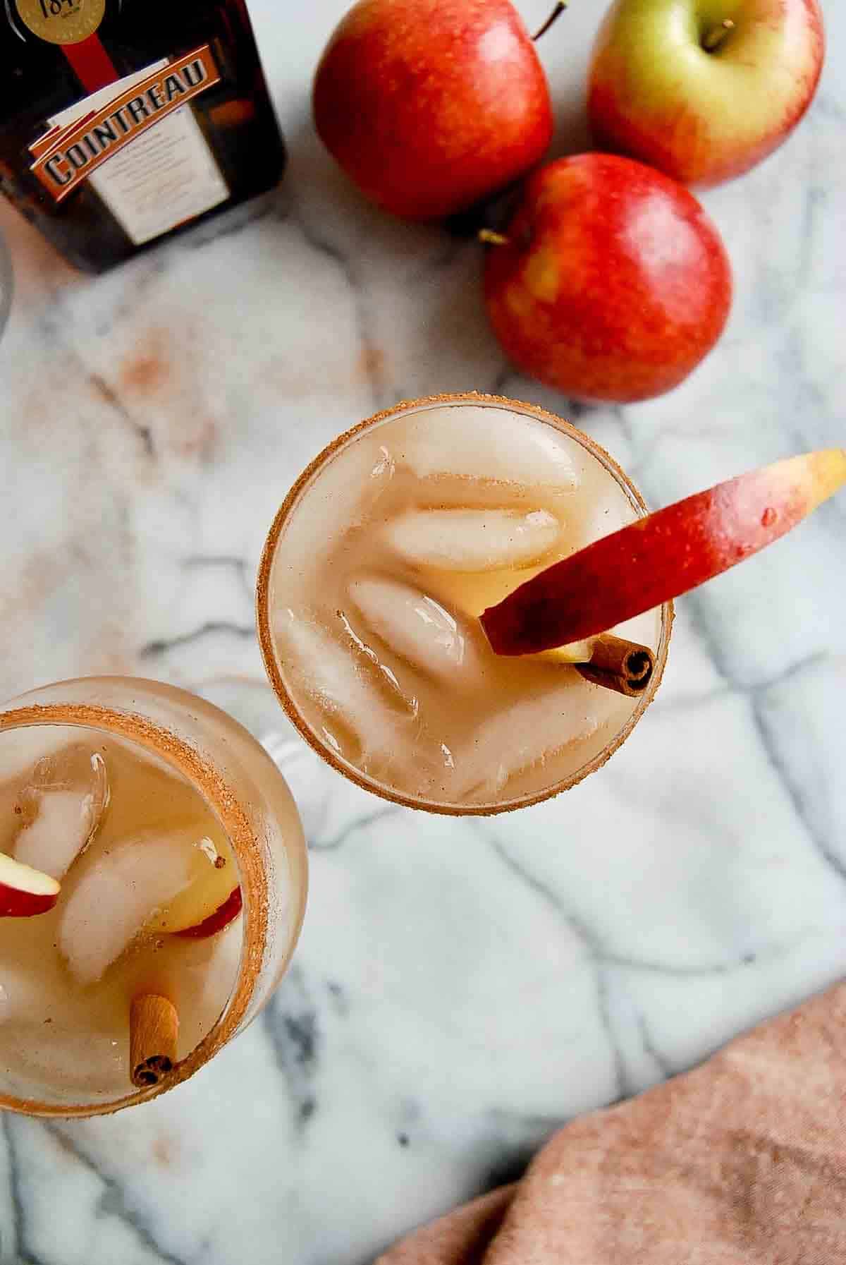 apple cider margaritas with cinnamon sugar rim on countertop.