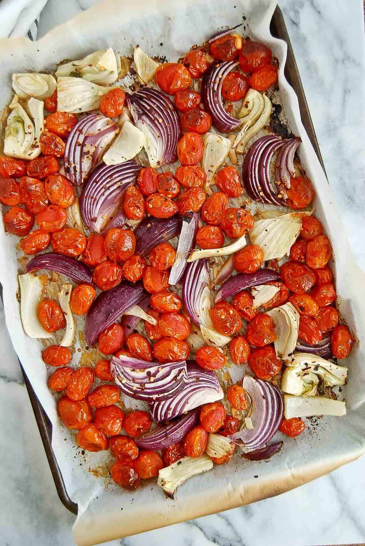 roasted tomatoes, onion, fennel and garlic on baking sheet.