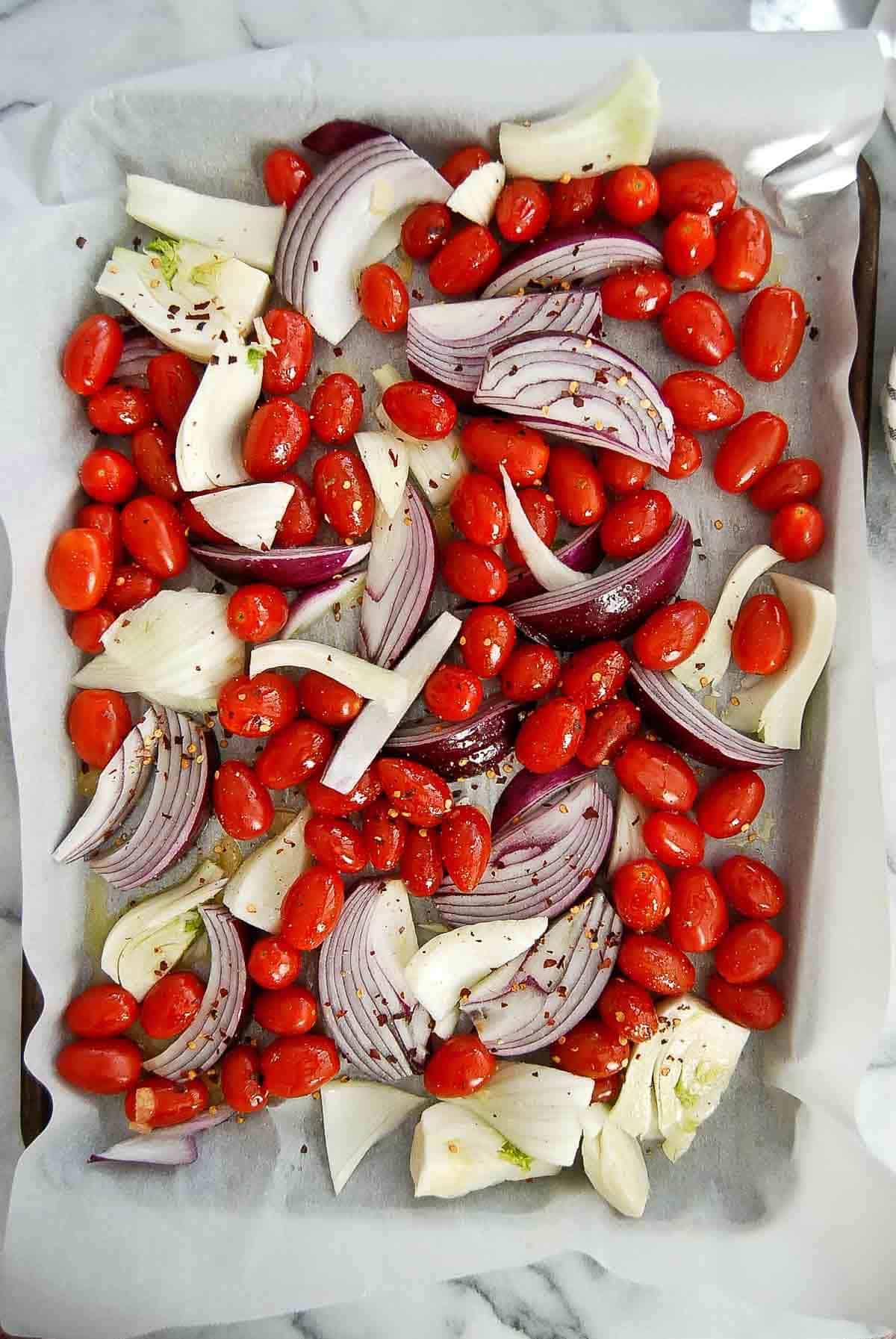 grape tomatoes, red onion, fennel, and garlic on sheet pan tossed with olive oil and crushed red pepper.