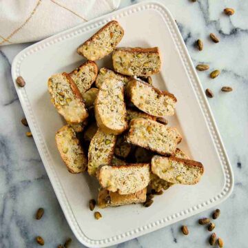 lemon biscotti with pistachio and lemon glaze on plate.