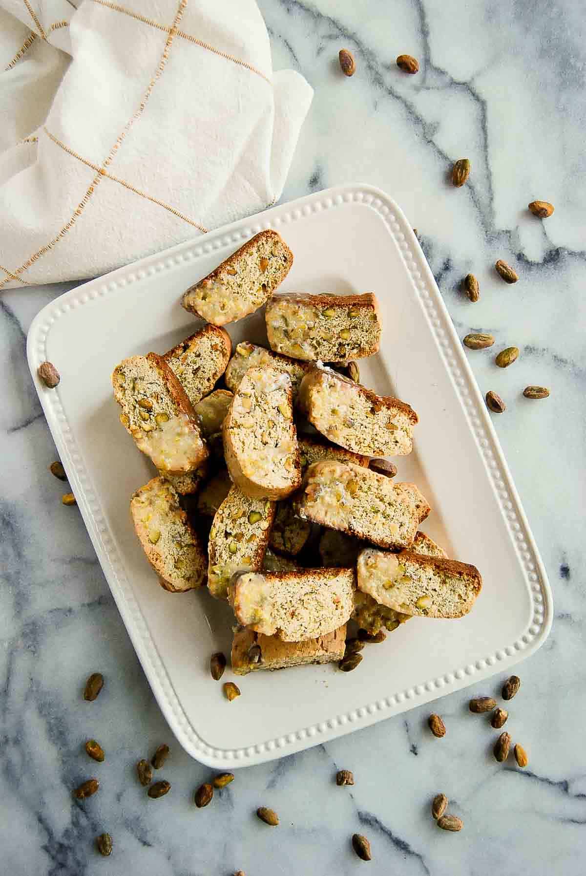 plate of lemon lemon biscotti cookies with pistachio and lemon glaze.