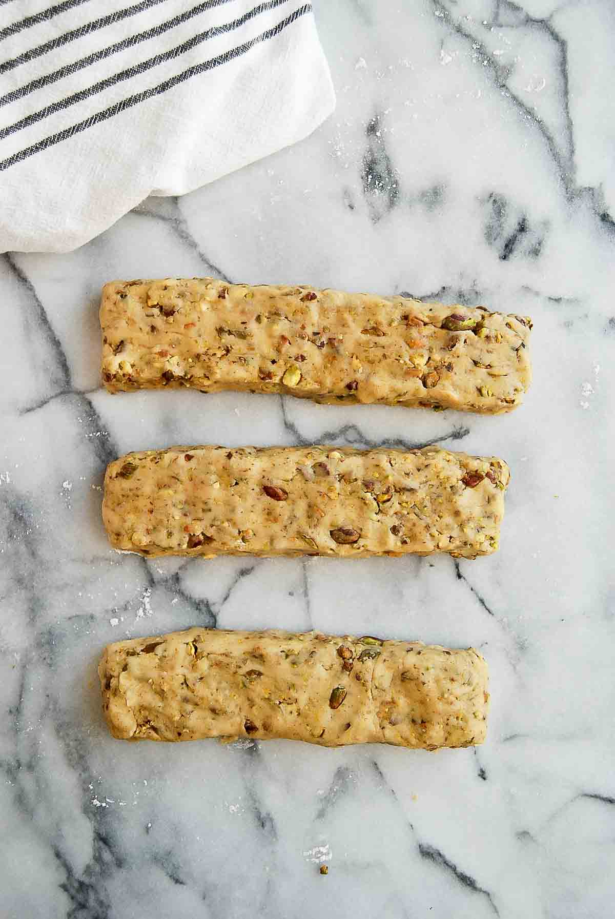 lemon biscotti dough with pistachios, divided into loaves.