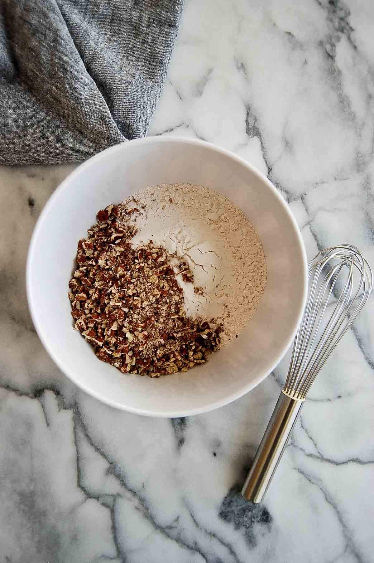 flour, salt and toasted pecans in bowl on countertop.