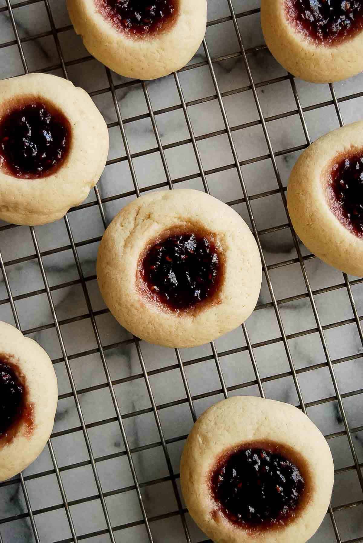 raspberry thumbprint cookies on cooling rack.