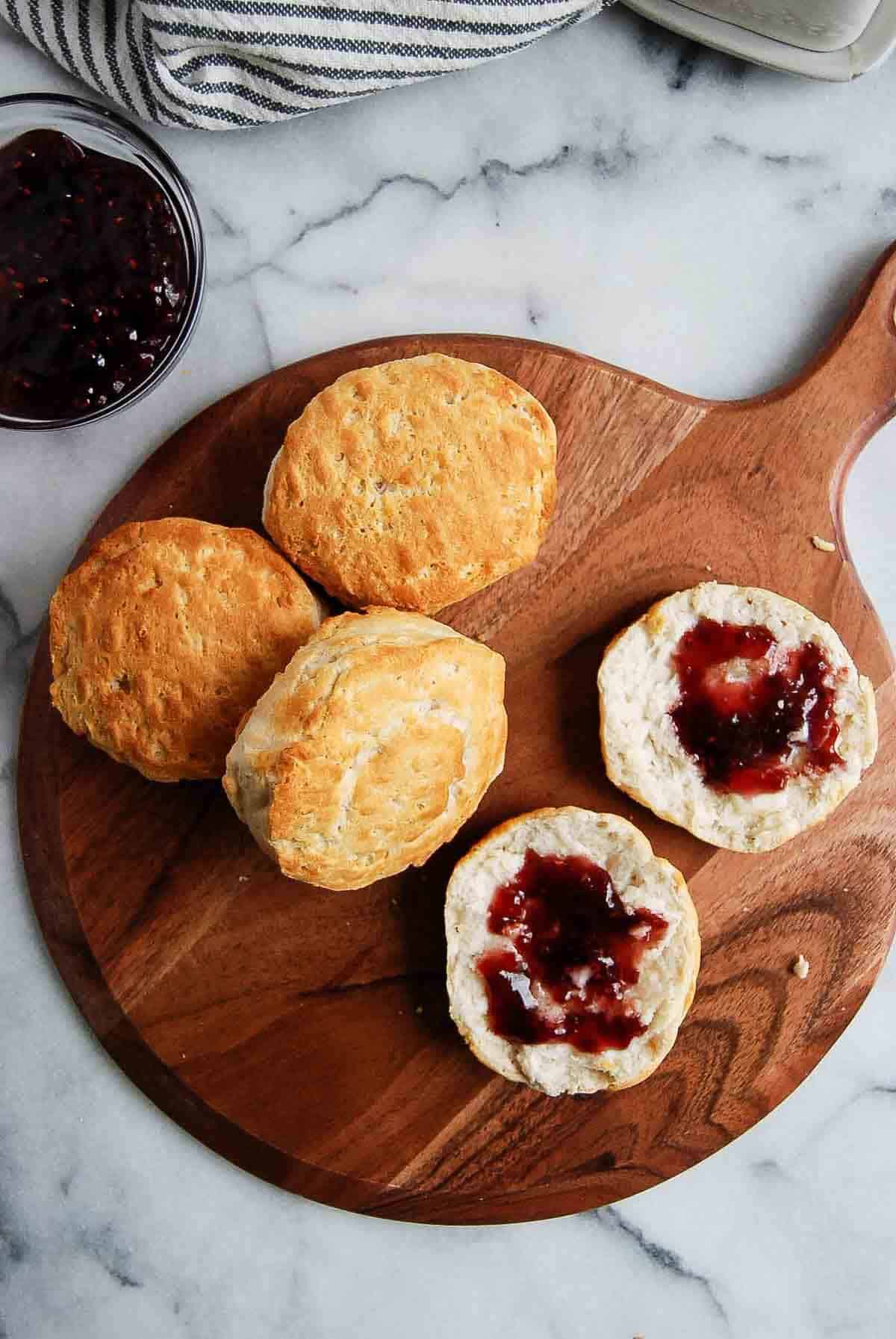 air fryer biscuits with butter and honey on cutting board.