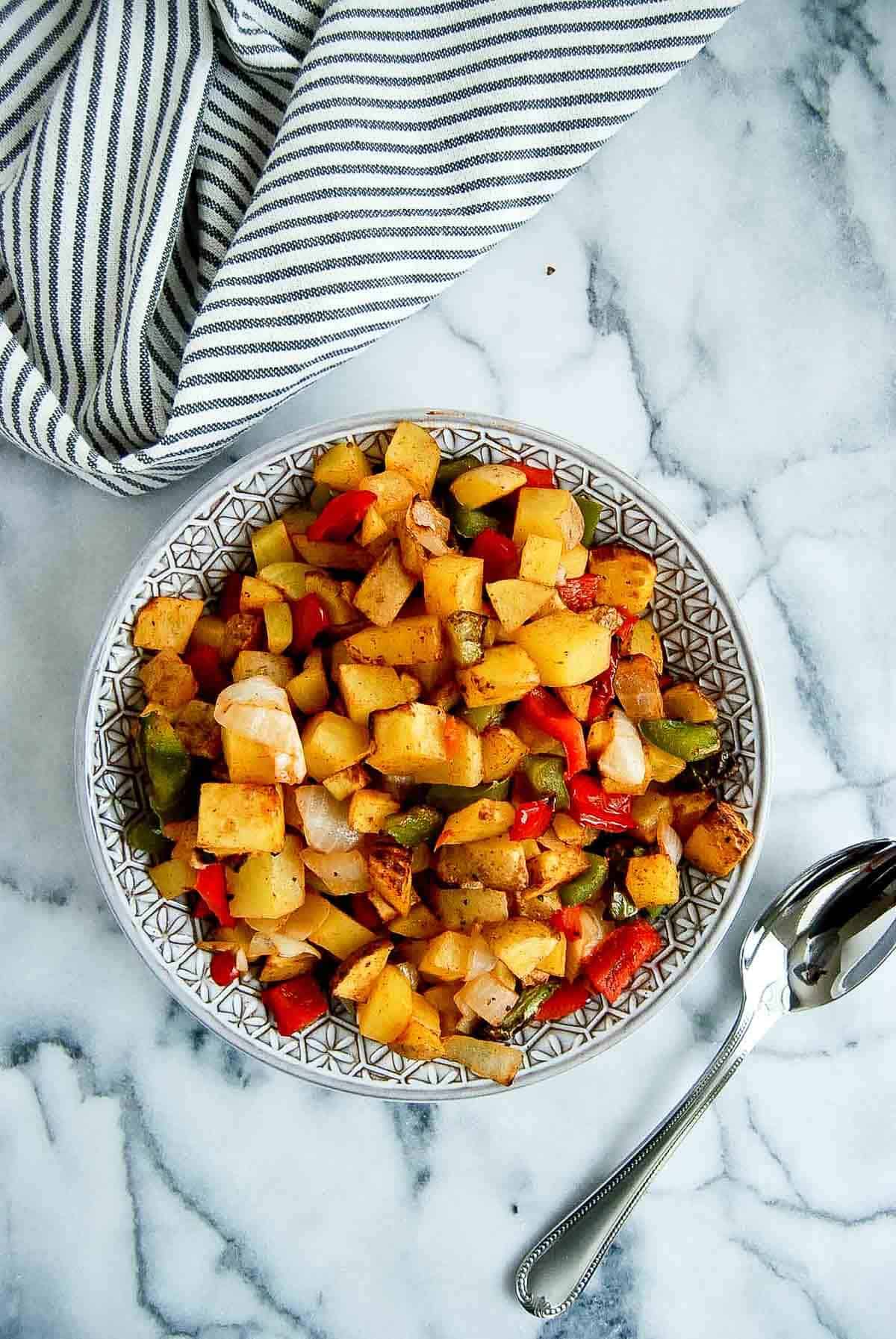 air fryer breakfast potatoes in bowl on countertop.