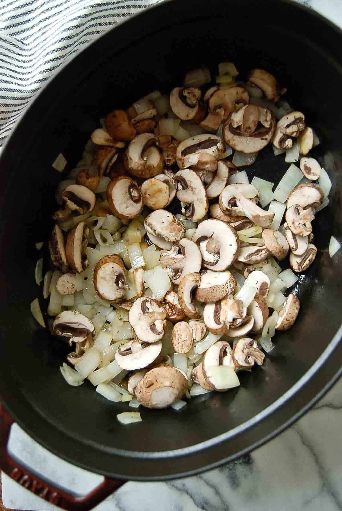 chopped onions and mushrooms sautéing in dutch oven.