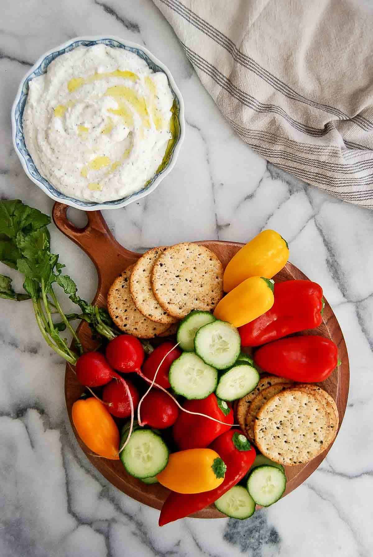 plate of veggies and crackers with cottage cheese ranch dip on the side.