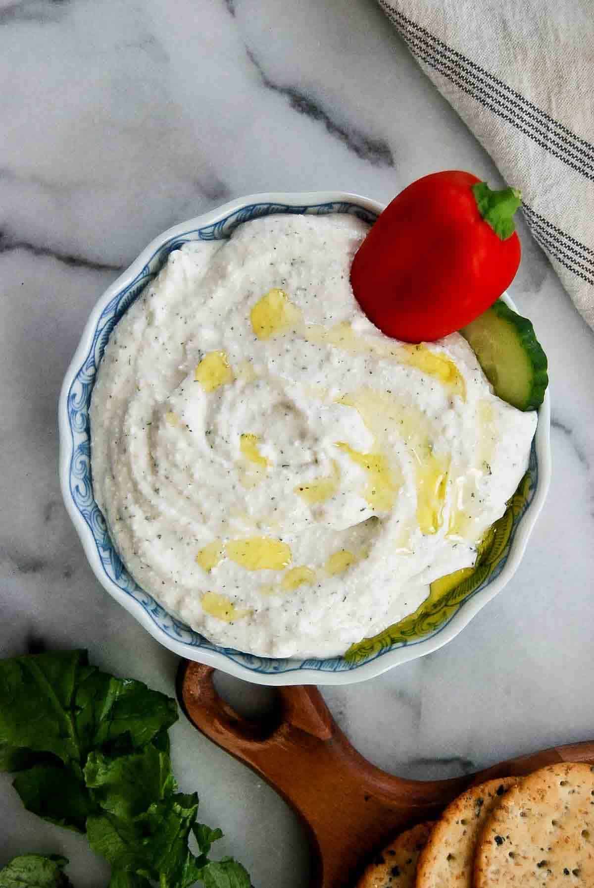 bowl of cottage cheese ranch dip with veggies and crackers on the side.