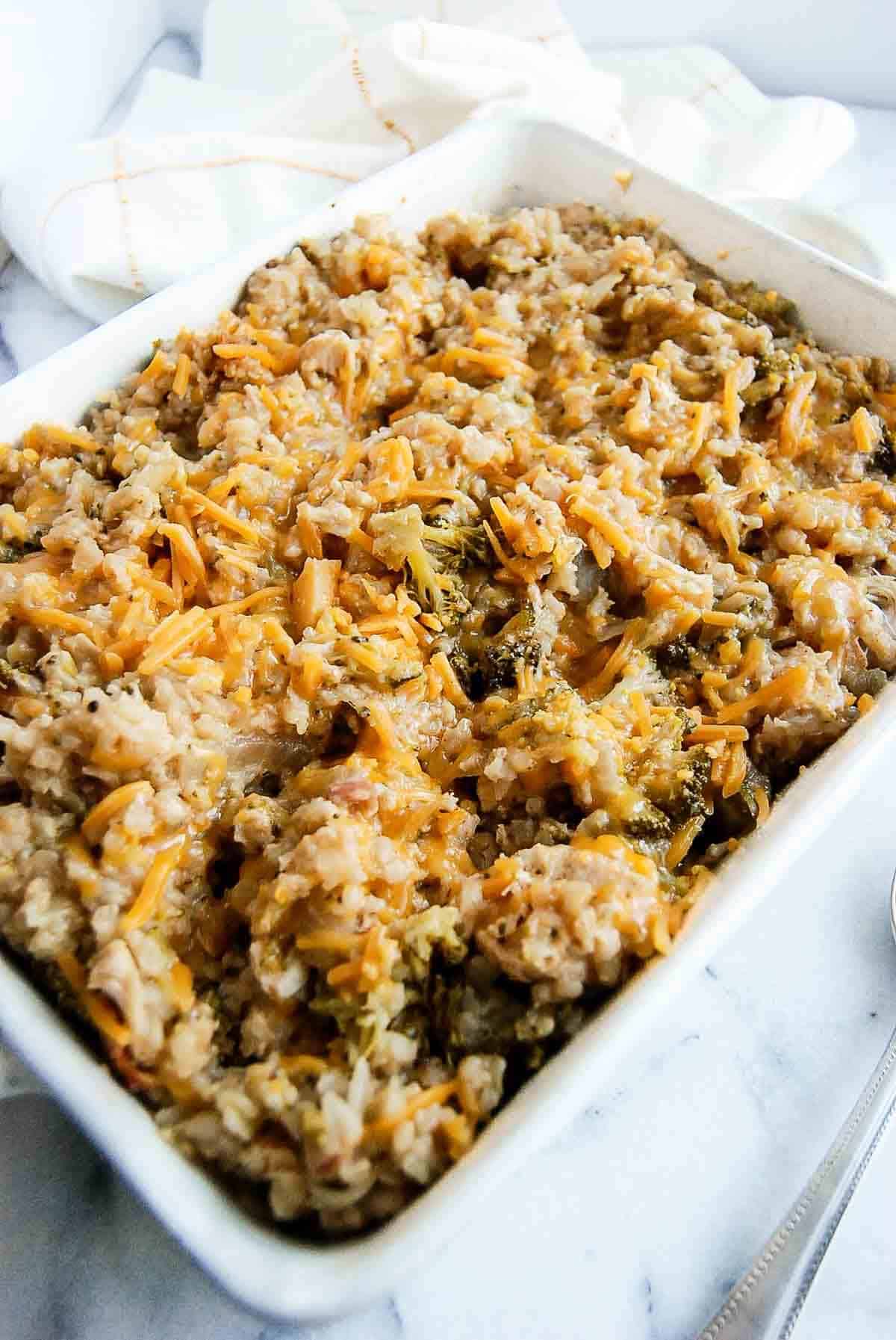 side view of cheesy chicken broccoli and rice casserole in serving dish.