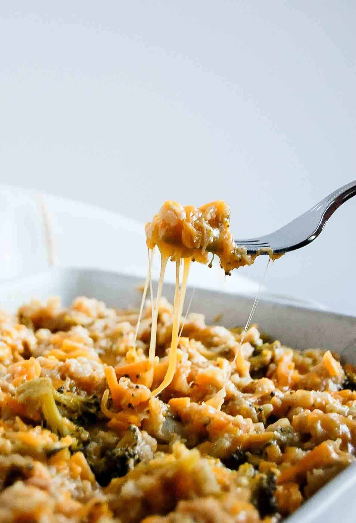 fork holding bite of chicken broccoli and rice casserole.