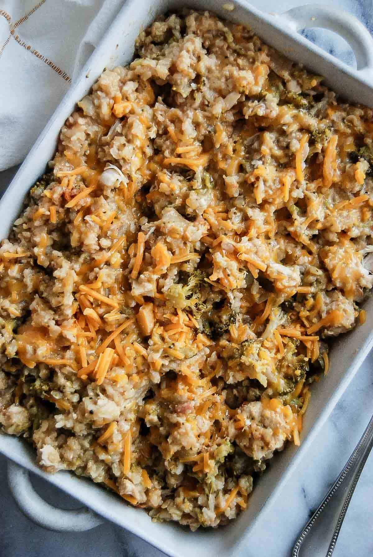 closeup of cheesy chicken broccoli and rice casserole in serving dish.