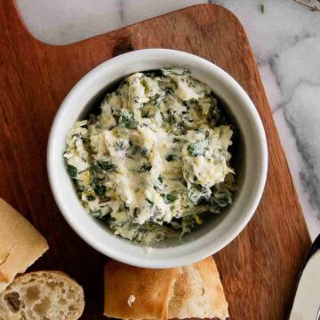 roasted garlic butter in bowl with bread on the side.