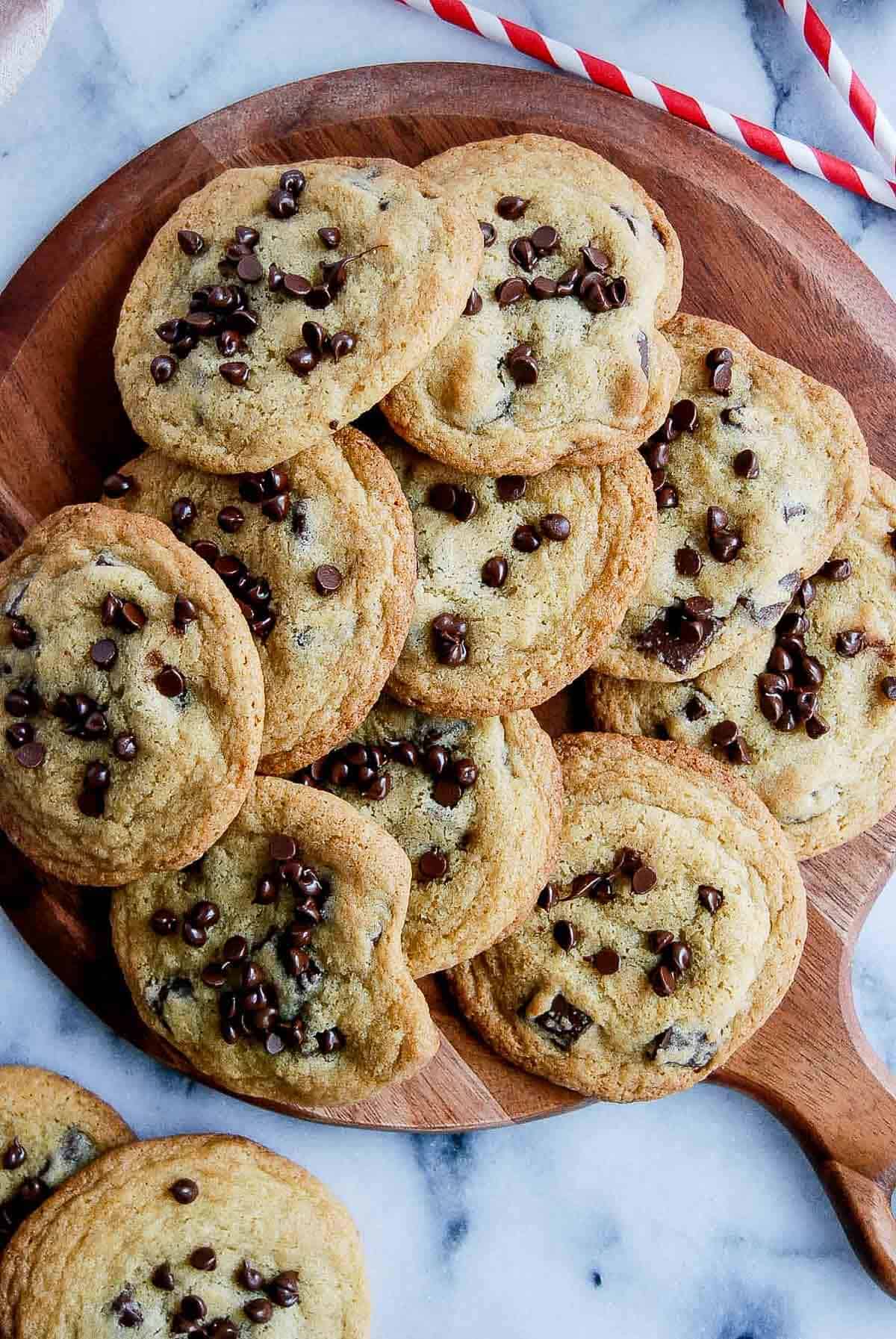 small batch chocolate chip cookies piled onto cutting board.