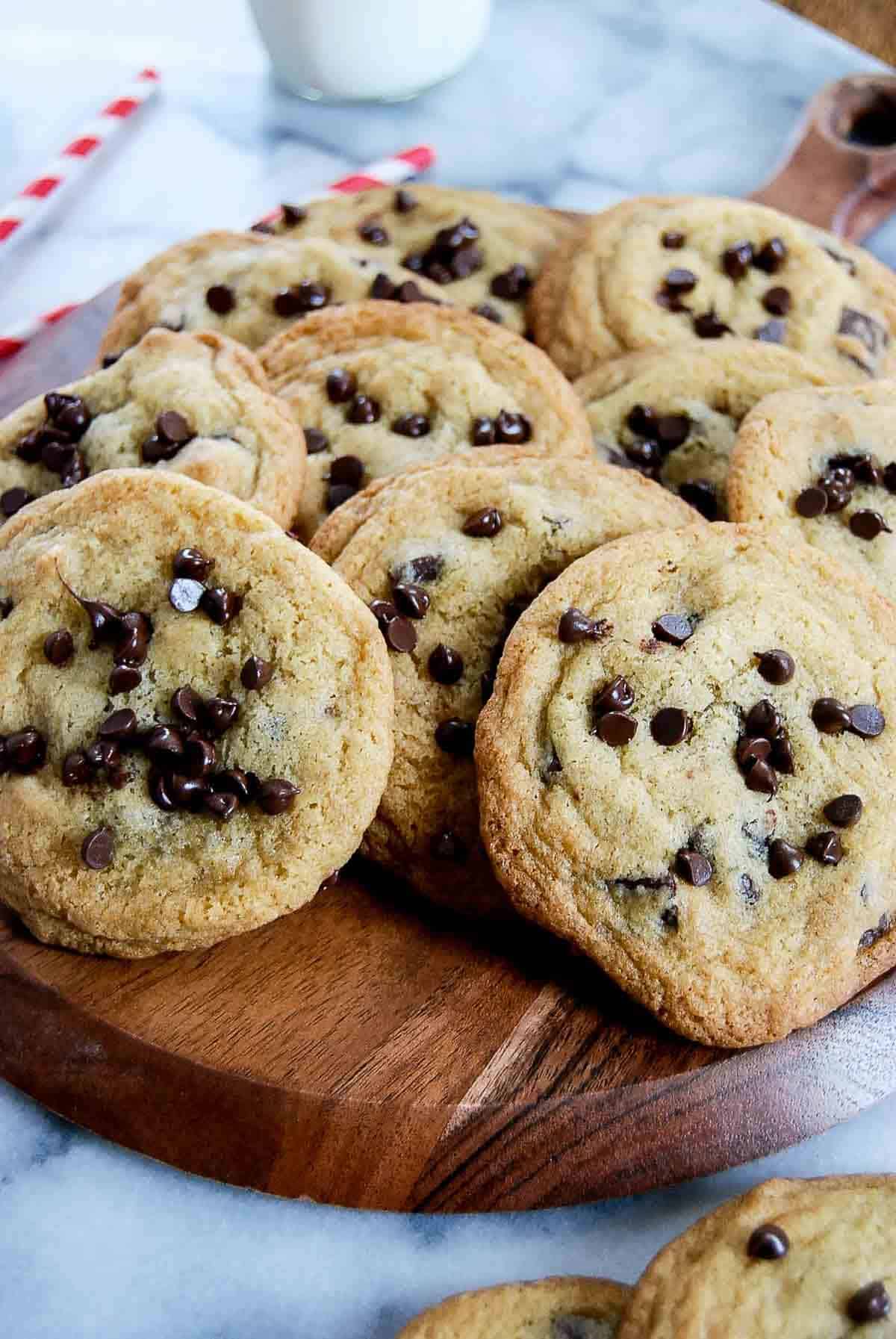 small batch chocolate chip cookies piled onto cutting board.